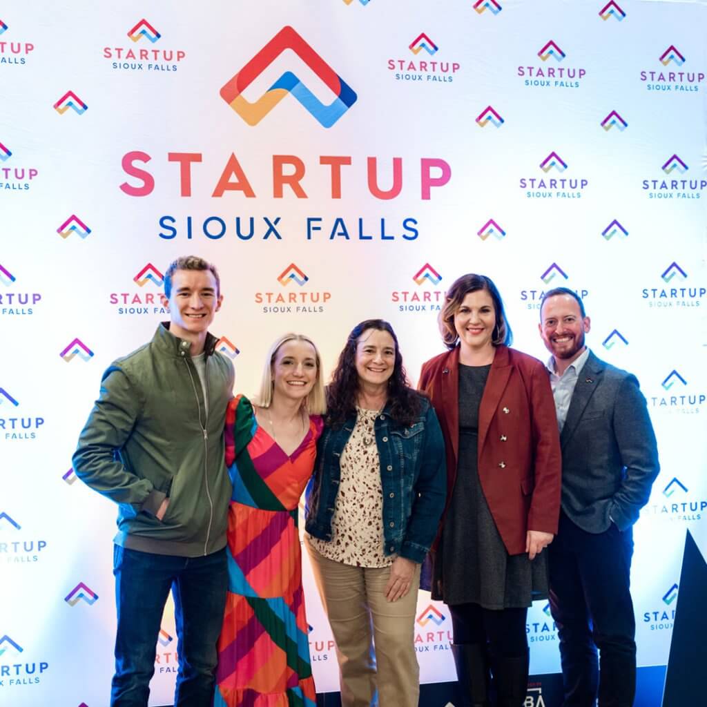 Startup Sioux Falls in front of their logo on a step and repeat